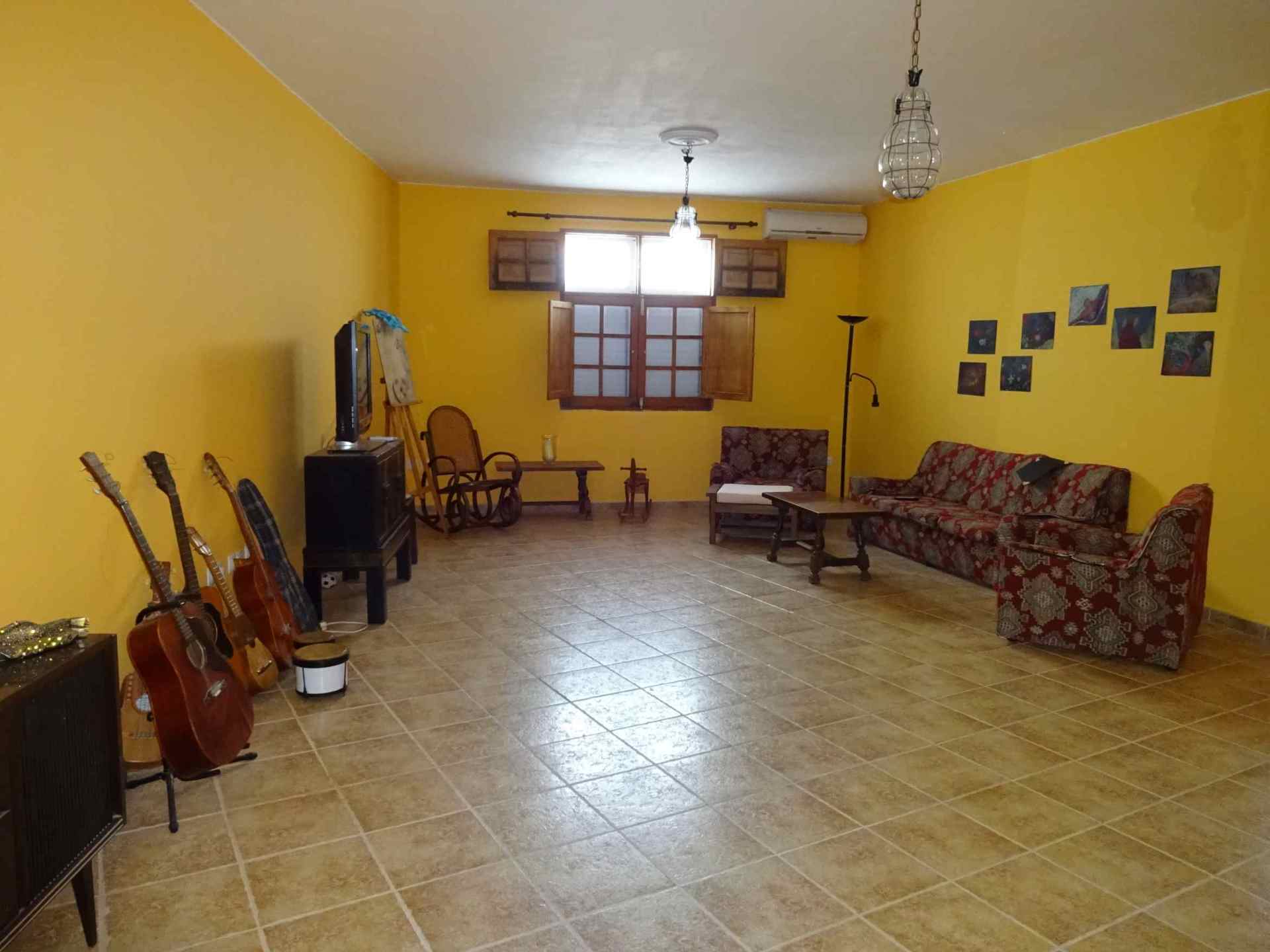 Ein Wohnzimmer mit gelben Wänden und einer Couch und Stühlen