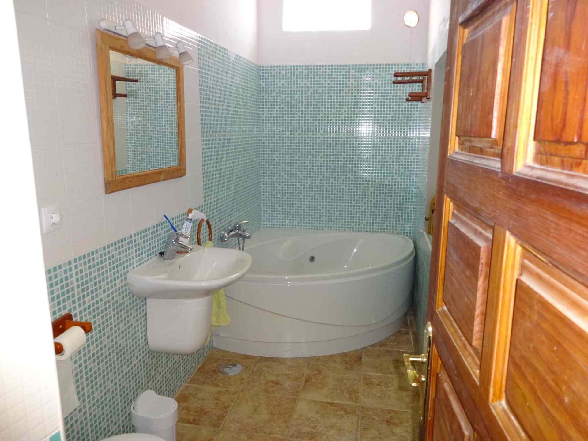 Ein Badezimmer mit Badewanne, Waschbecken und Spiegel