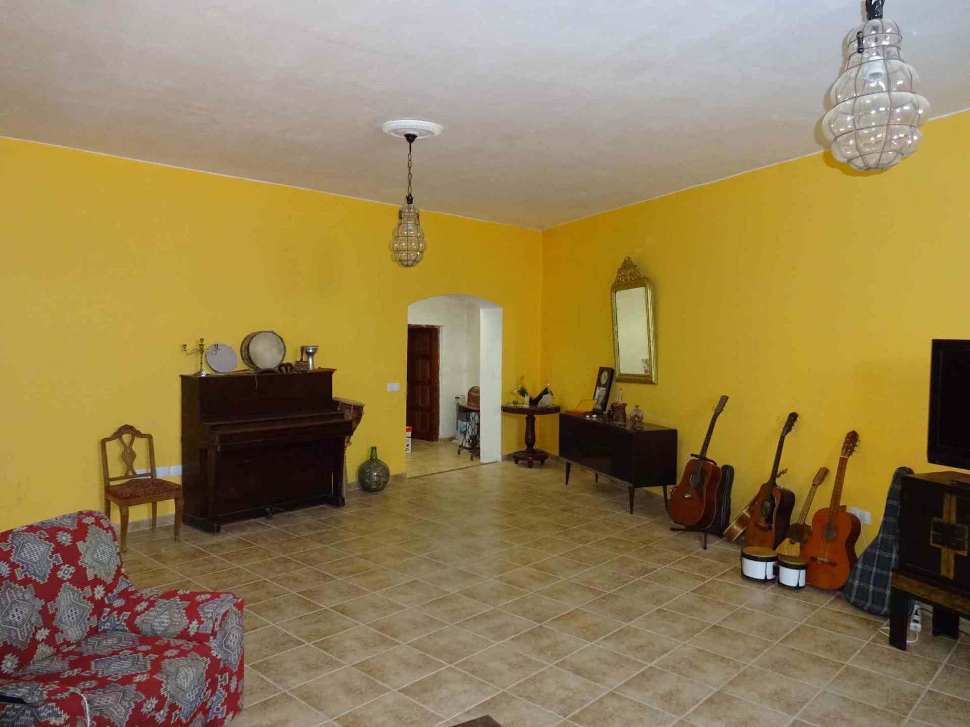 Ein Wohnzimmer mit einem Klavier und Gitarren auf dem Boden