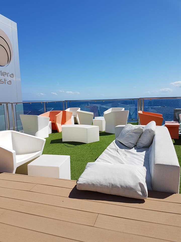 Eine Couch und Stühle auf einer Terrasse mit Blick auf den Ozean