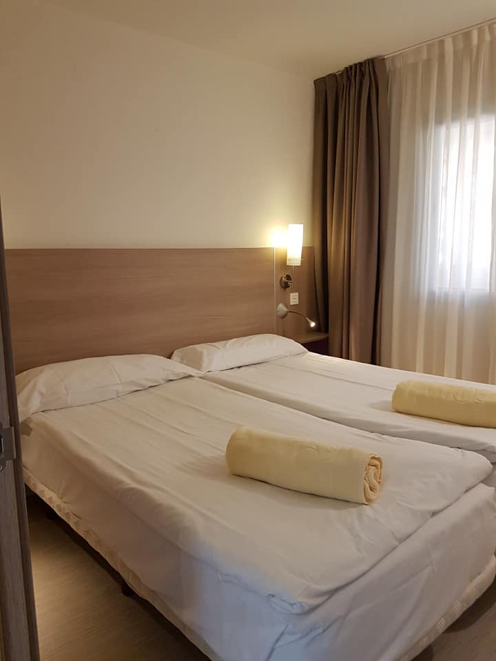 Ein Hotelzimmer mit zwei Betten und einem Fenster.