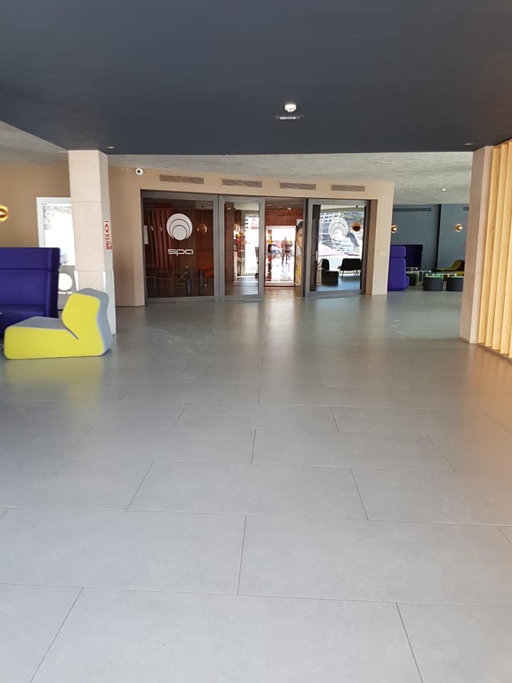 Eine große, leere Lobby mit einem Sofa und Stühlen darin.