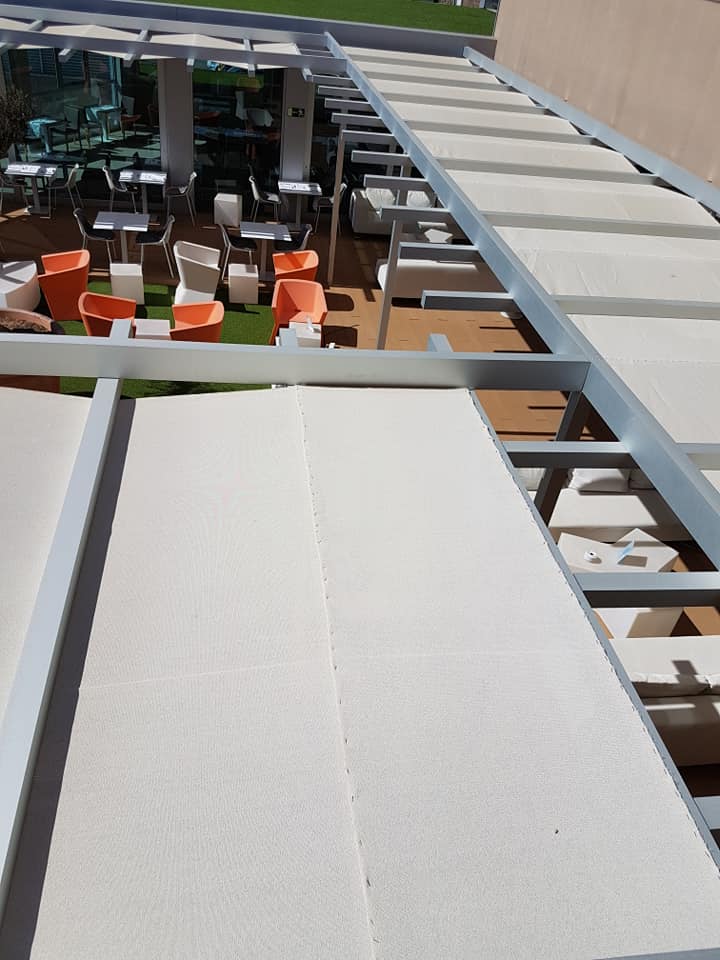 Eine Terrasse mit Tischen und Stühlen unter einem Baldachin