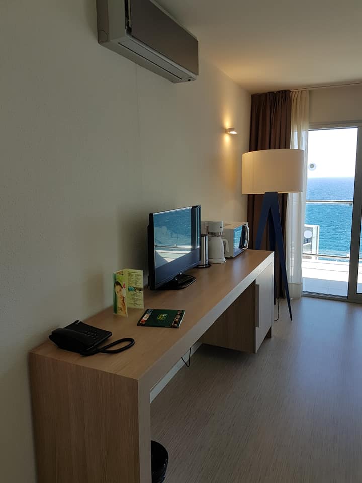 Ein Hotelzimmer mit Schreibtisch und Flachbildfernseher
