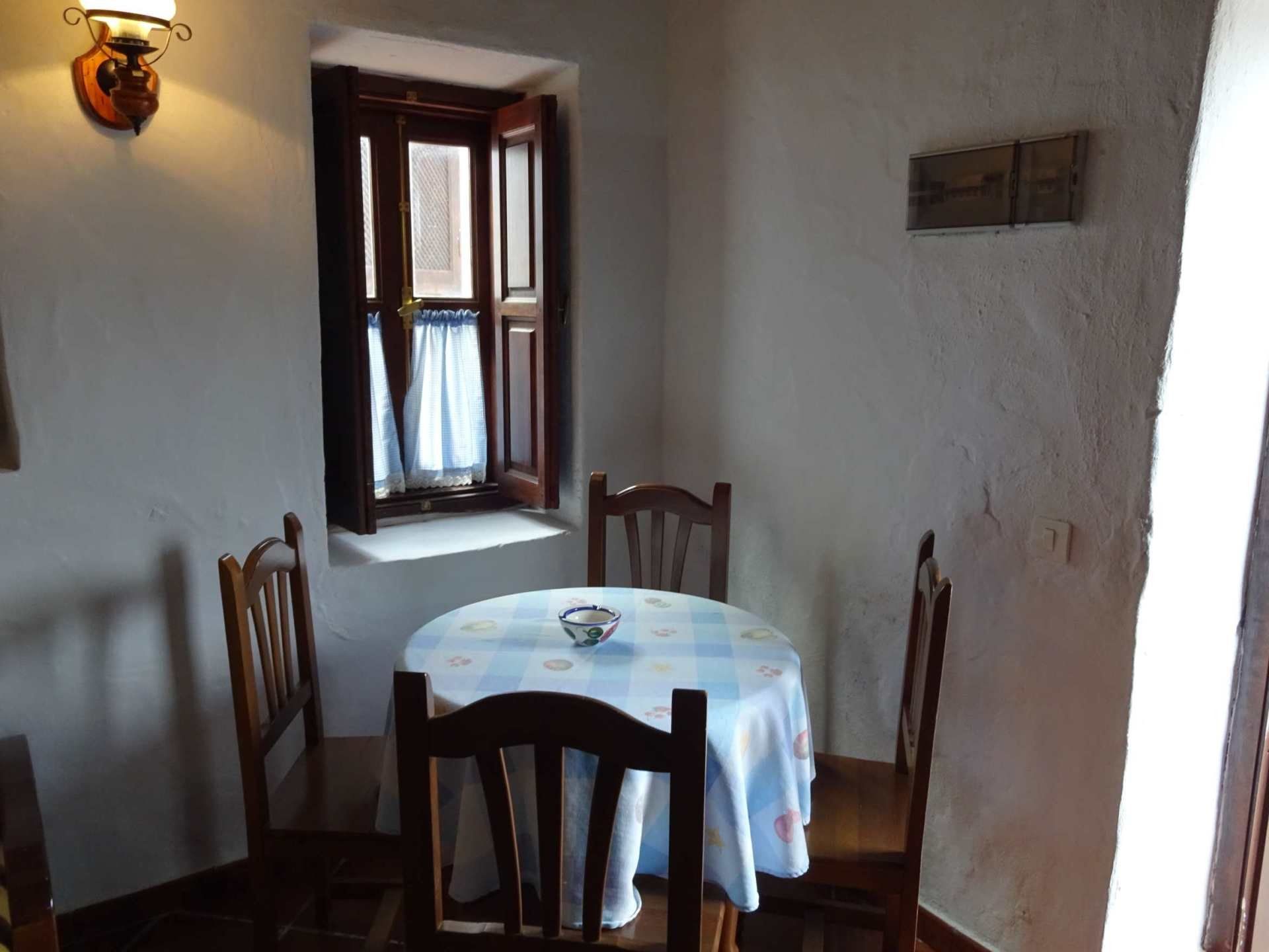 Ein Raum mit einem Tisch und Stühlen vor einem Fenster