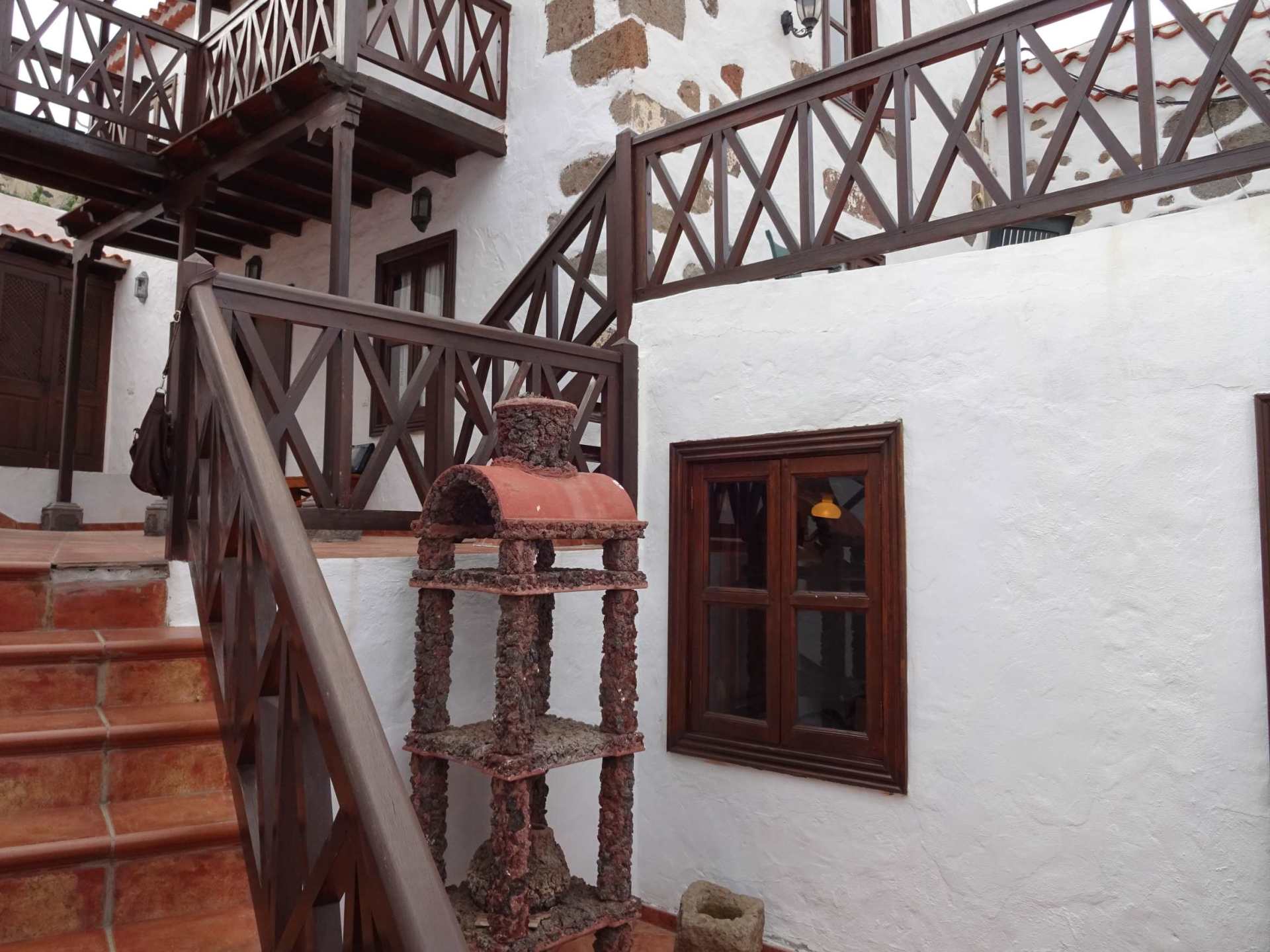 Treppe führt hinauf zu einem weißen Gebäude mit einem Holzgeländer