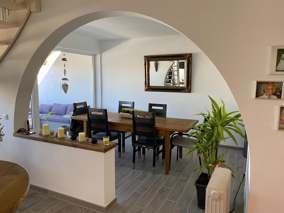Ein Esszimmer mit Tisch und Stühlen und einem Spiegel an der Wand.
