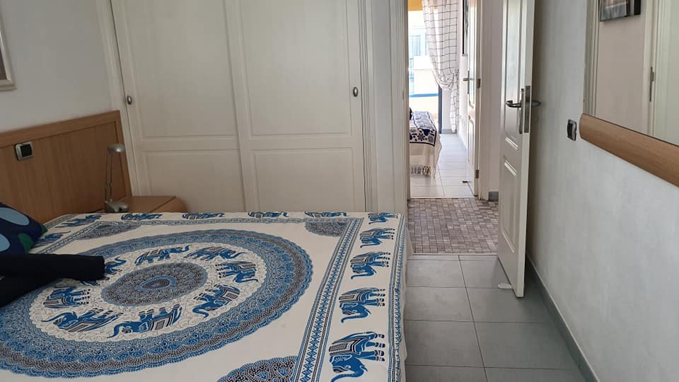 Ein Schlafzimmer mit einem Bett und einer blau-weißen Decke mit Elefanten darauf