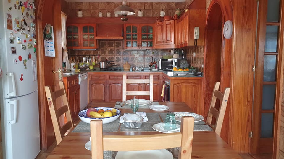Eine Küche mit Tisch und Stühlen und einem Kühlschrank.
