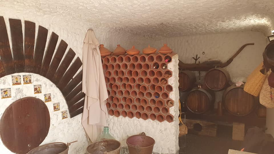 Ein Raum mit vielen Fässern und Töpfen an der Wand.