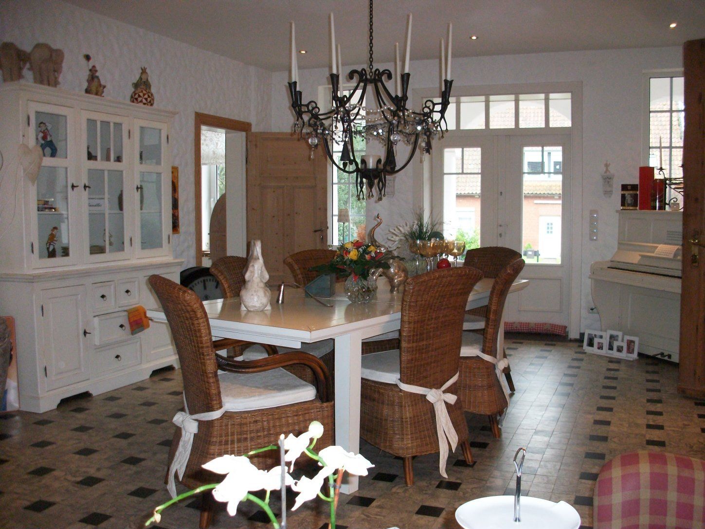 Ein Esszimmer mit Korbstühlen und einem Kronleuchter