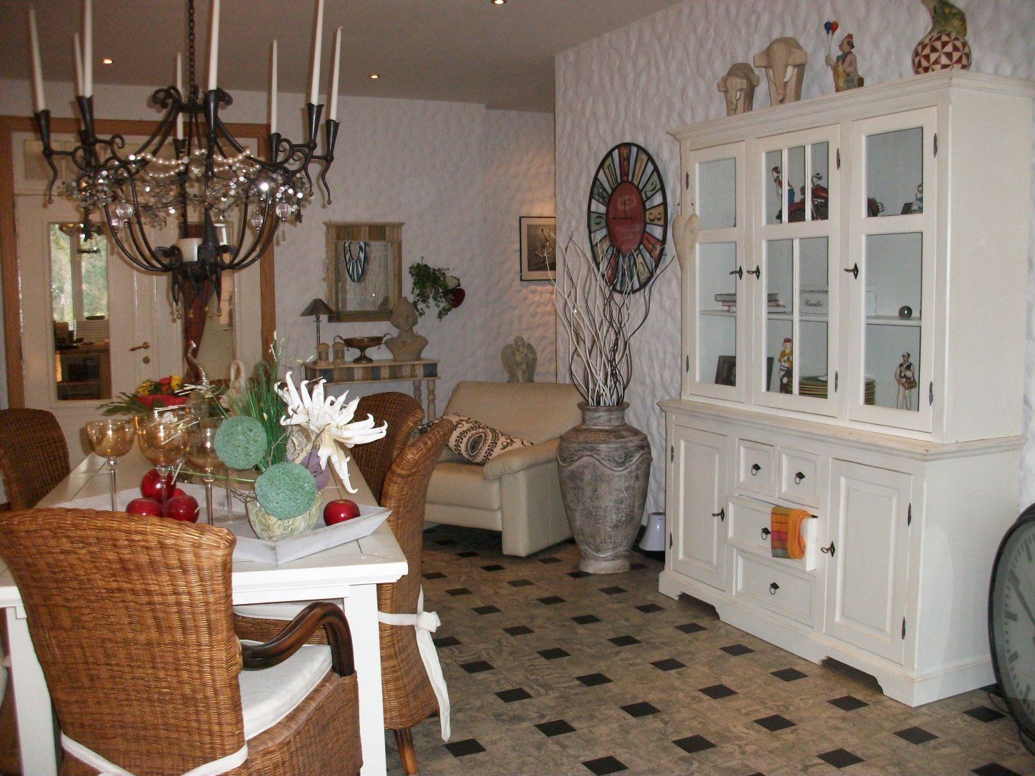 Ein Wohnzimmer mit einem Tisch und Stühlen und einer Uhr an der Wand