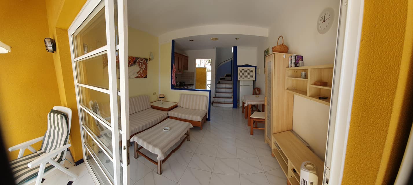 Ein Wohnzimmer mit einer Couch und Stühlen und einer Uhr an der Wand.