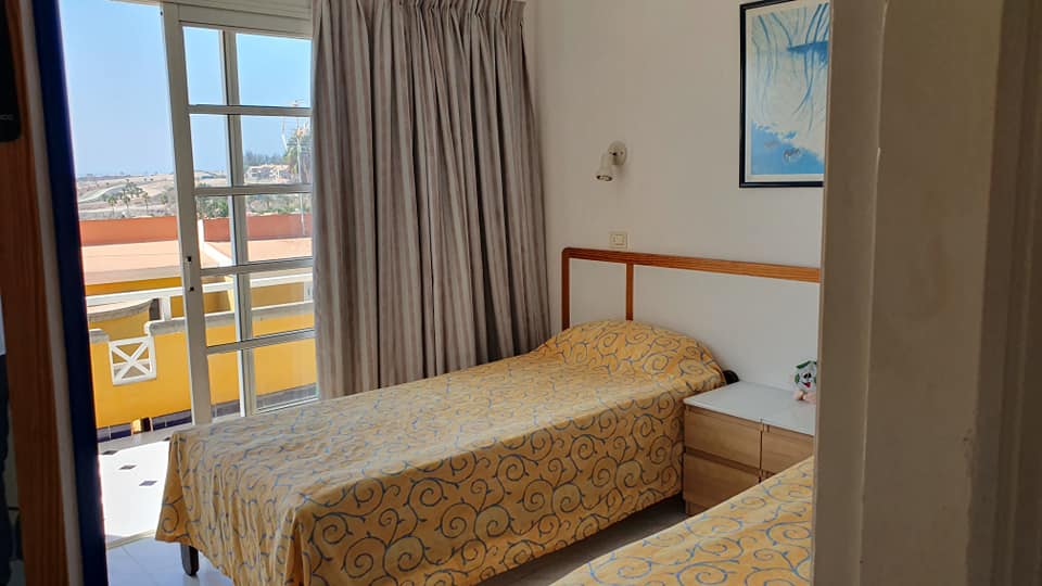 Ein Schlafzimmer mit zwei Betten und einer Glasschiebetür.