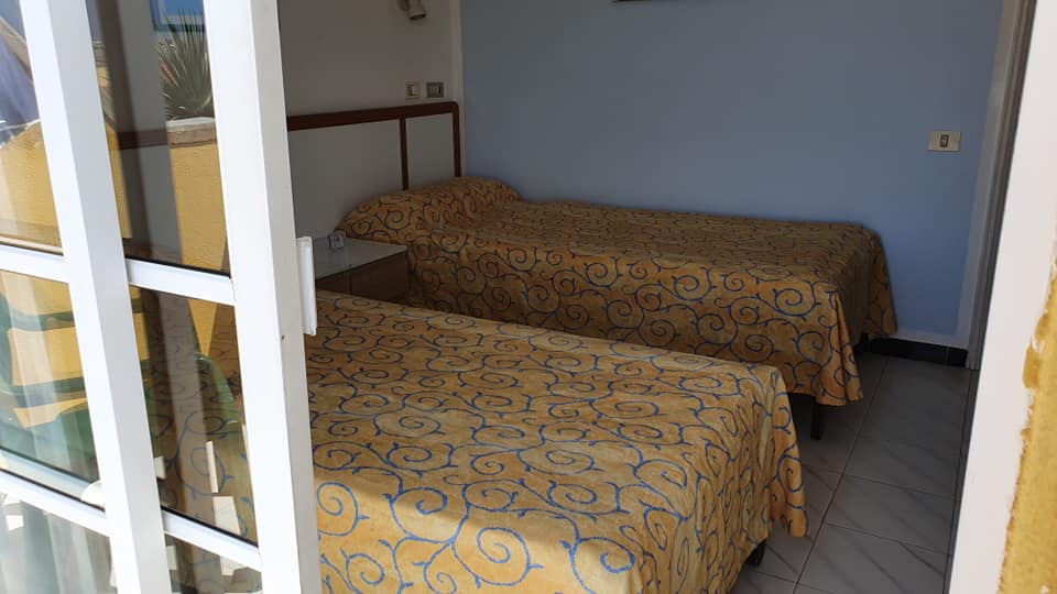 Ein Schlafzimmer mit zwei Betten und einer Glasschiebetür