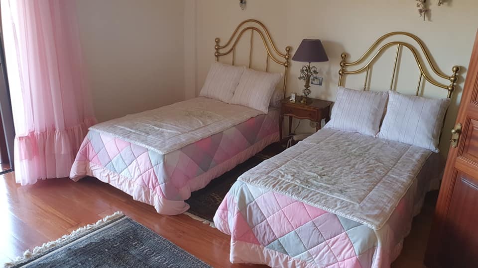 Ein Schlafzimmer mit zwei Einzelbetten und einer Lampe.