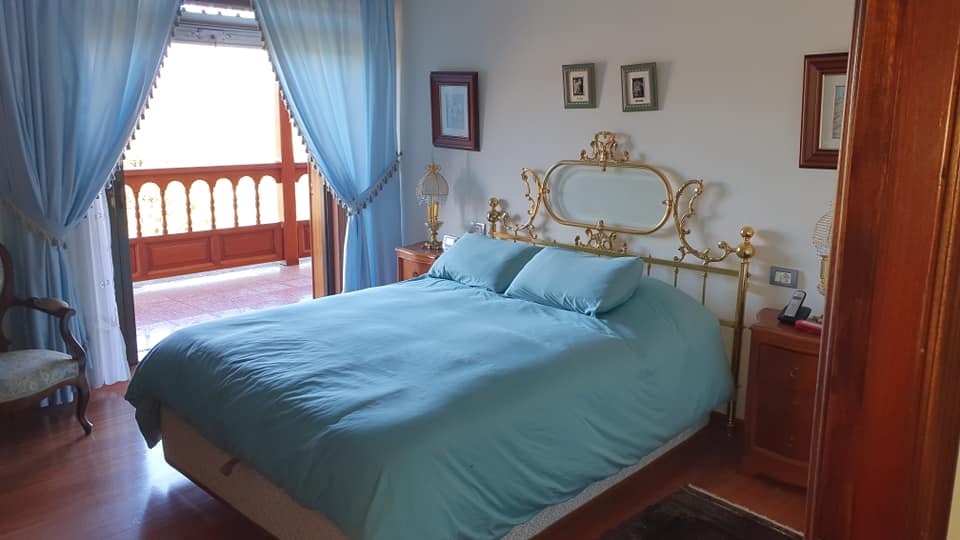 Ein Schlafzimmer mit großem Bett und blauen Vorhängen