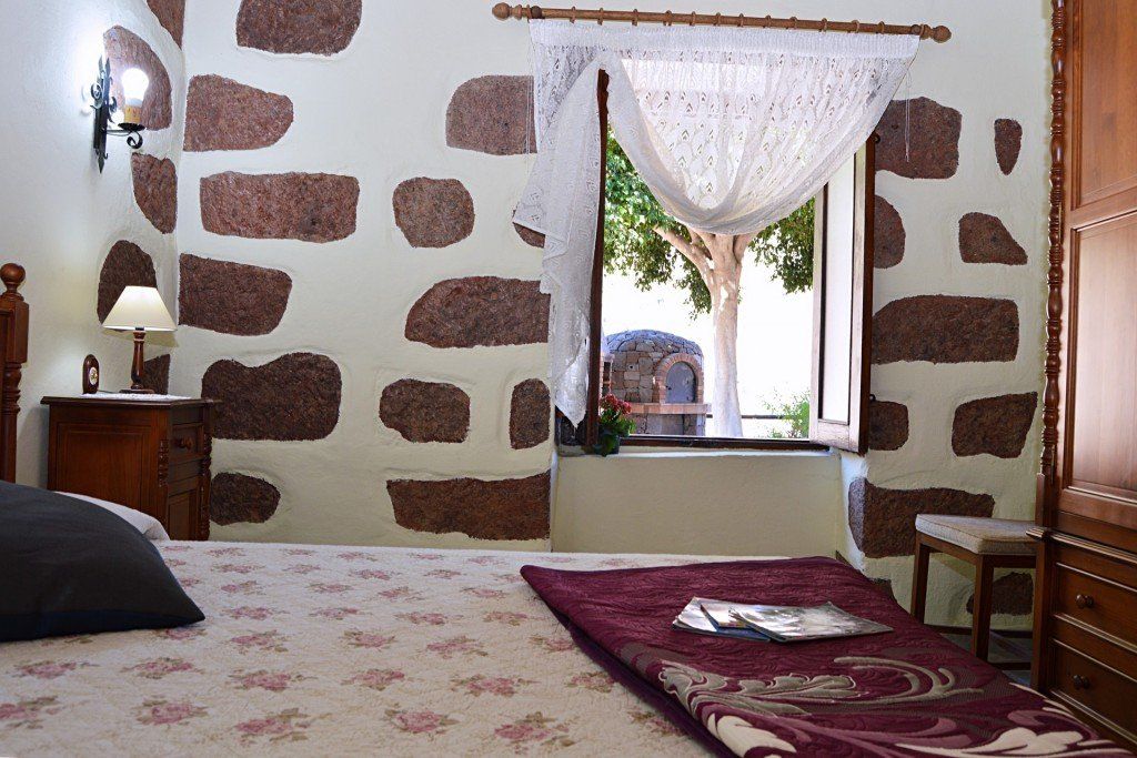 Ein Schlafzimmer mit einem Bett und einem Fenster mit einer Ziegelwand