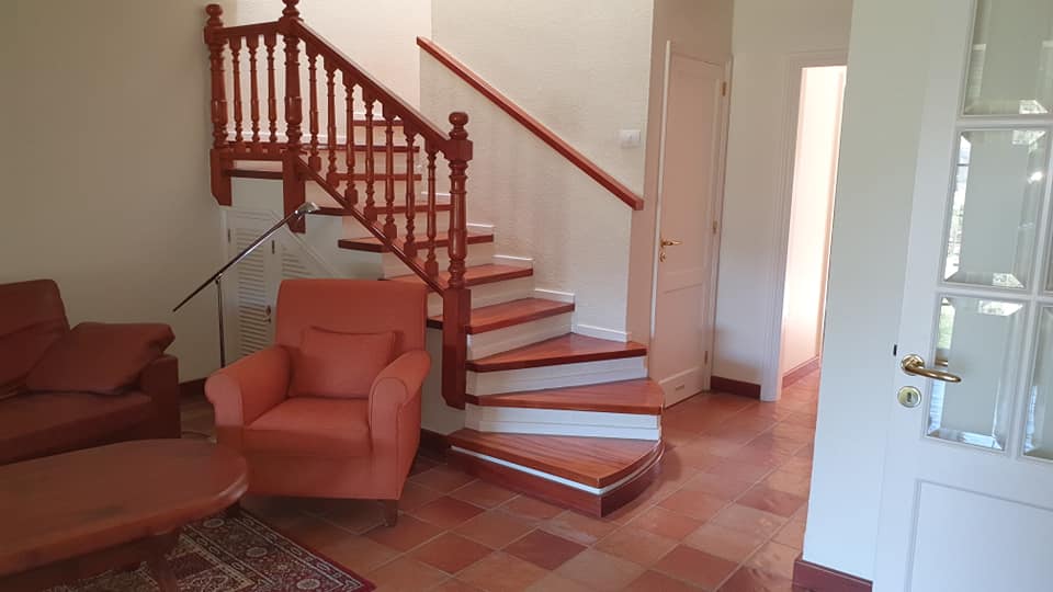 Ein Wohnzimmer mit einer Treppe, die in den zweiten Stock führt.
