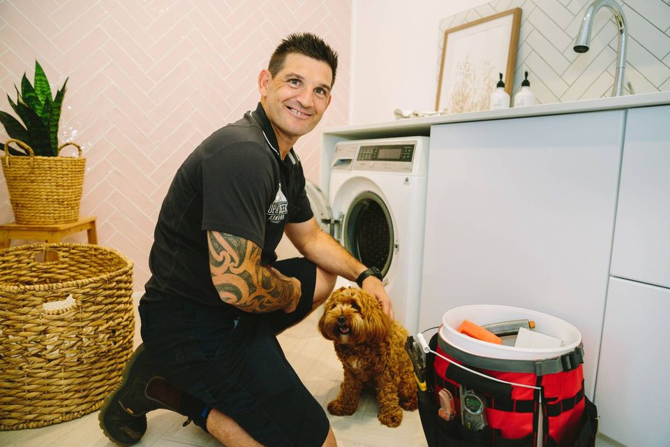 Plumber fixing a hot water system pipe — Emergency plumber in Tugun, QLD Plumber fixing a hot water system pipe — Emergency plumber in Tugun, QLD