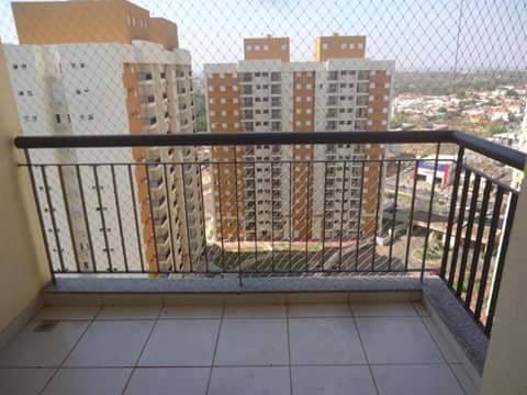 Varanda com piso de azulejo com vista para altos prédios de apartamentos em uma paisagem urbana.