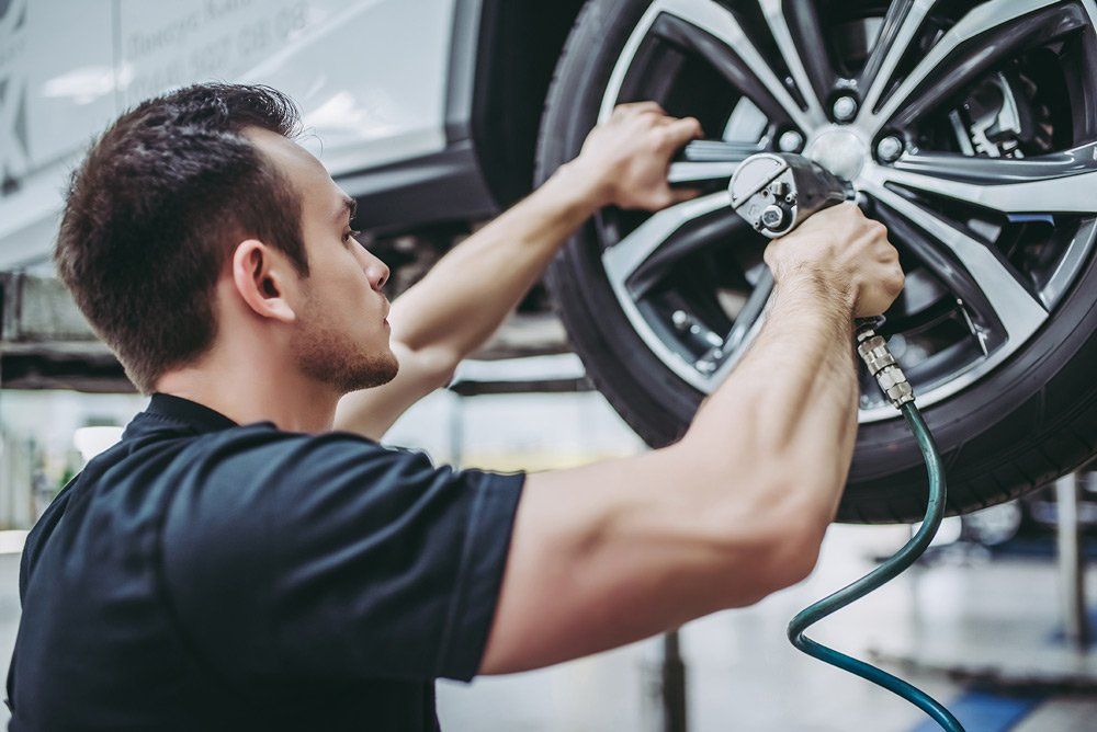 mechanic working on vehicle wheel