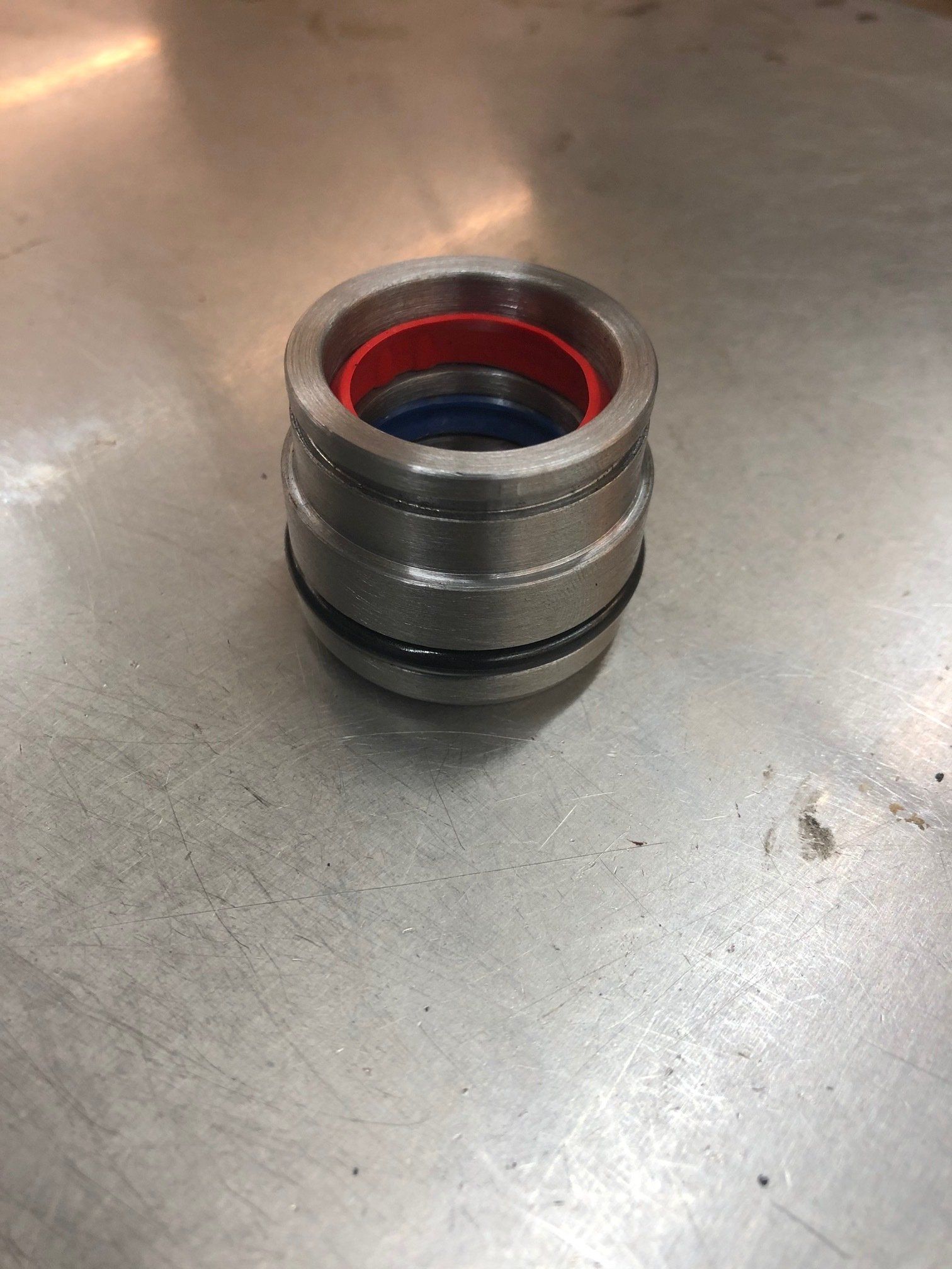 A metal ring with a red and blue seal is sitting on a metal surface.