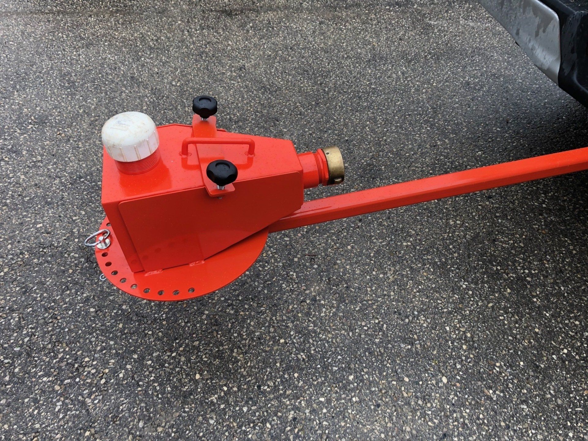 A red object is attached to the back of a truck.