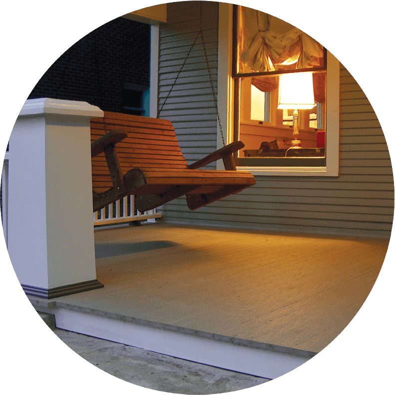 A porch with a swing and a lamp on it