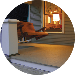 A porch with a swing and a lamp on it