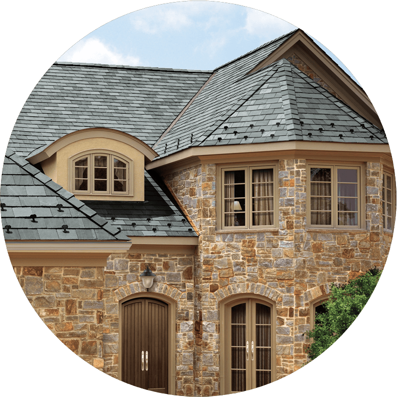 A stone house with a slate roof and arched windows