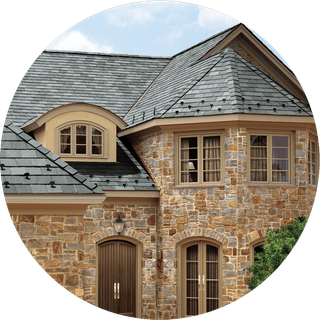 A stone house with a slate roof and arched windows