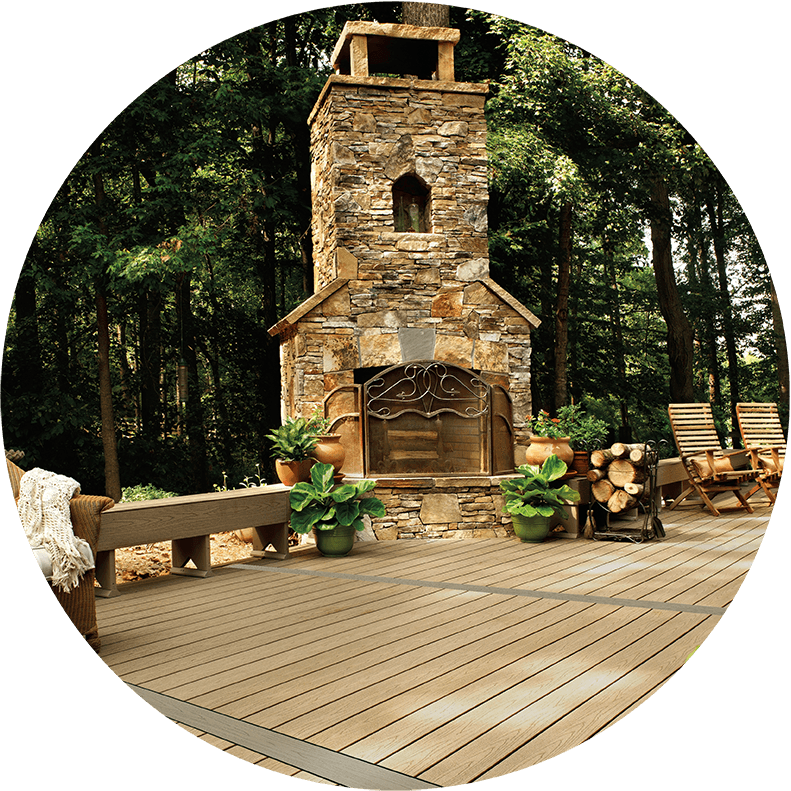 A wooden deck with a stone fireplace in the middle