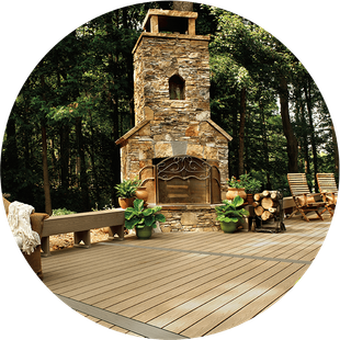 A wooden deck with a stone fireplace in the middle