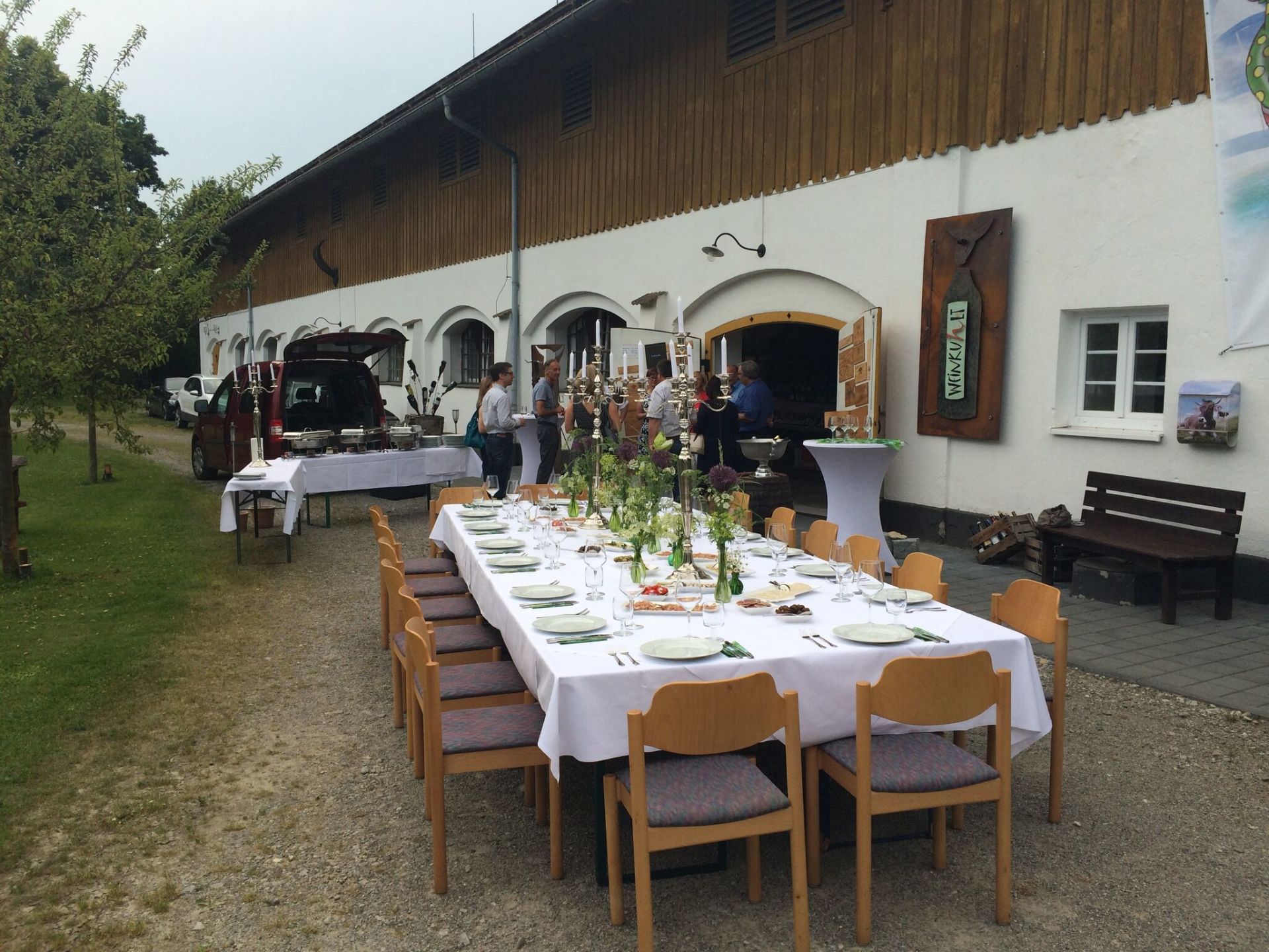 Ein langer Tisch mit Stühlen vor einem Gebäude