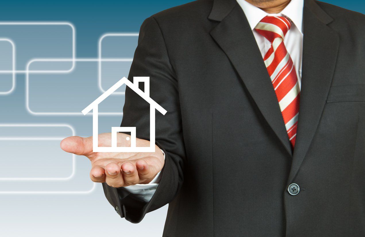 man in suit holding house