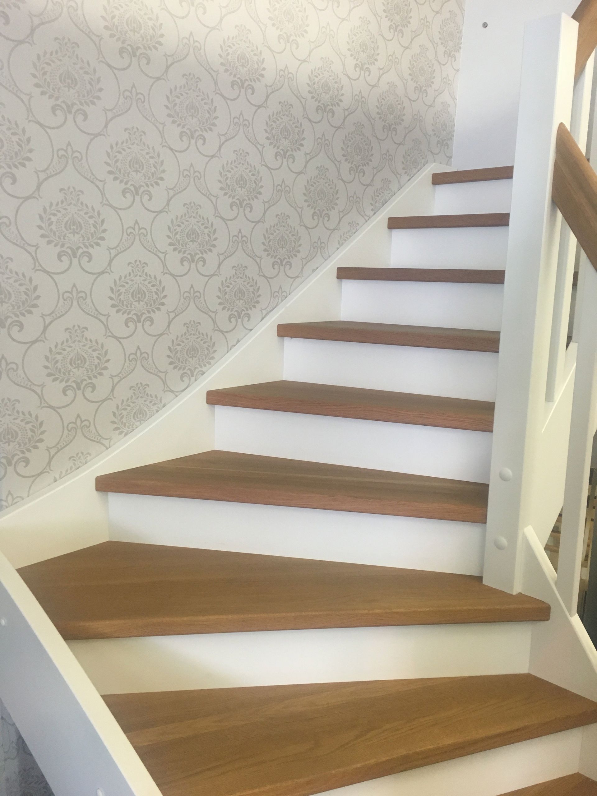 Treppe aus Holz mit grauer Mustertapete