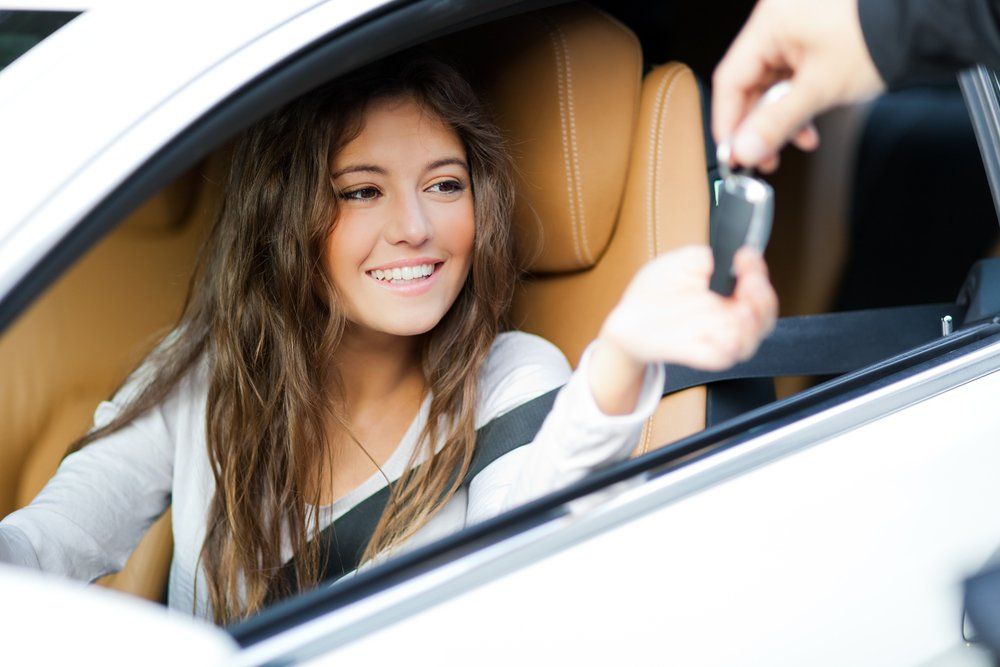 Young lady getting her keys to her new car