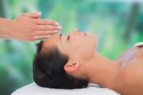 Beautiful brunette getting reiki therapy at a luxury spa