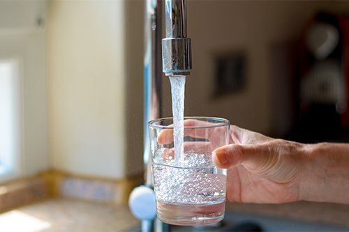 Filling Glass Of Water From Tap — Fresno, CA — Art Douglas Plumbing Inc. Filling Glass Of Water From Tap — Fresno, CA — Art Douglas Plumbing Inc.