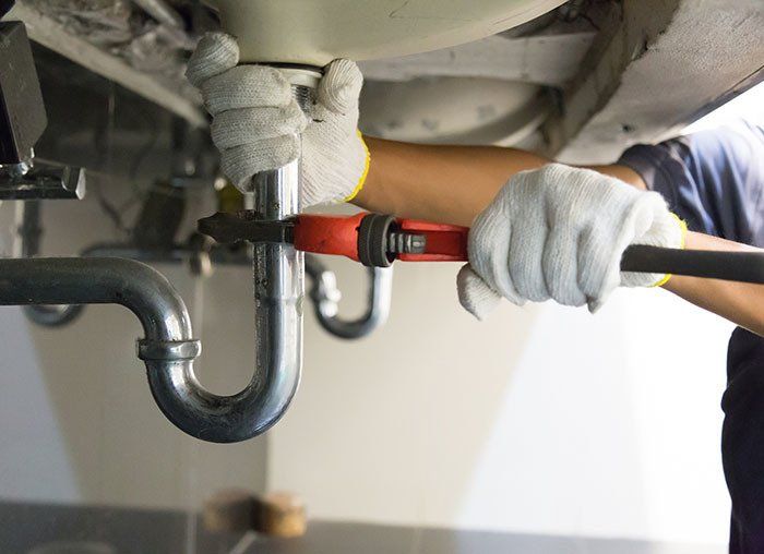 Plumber Fixing White Sink Pipe — Fresno, CA — Art Douglas Plumbing Inc.