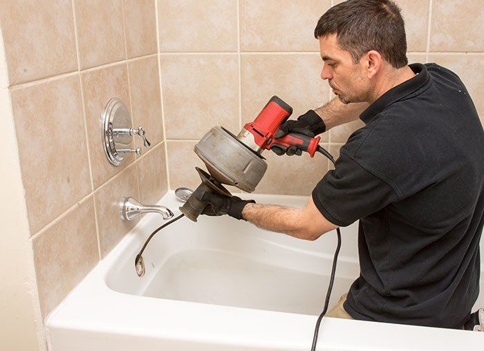 Plumber Unclogging a Tub Drain — Fresno, CA — Art Douglas Plumbing Inc. Plumber Unclogging a Tub Drain — Fresno, CA — Art Douglas Plumbing Inc.
