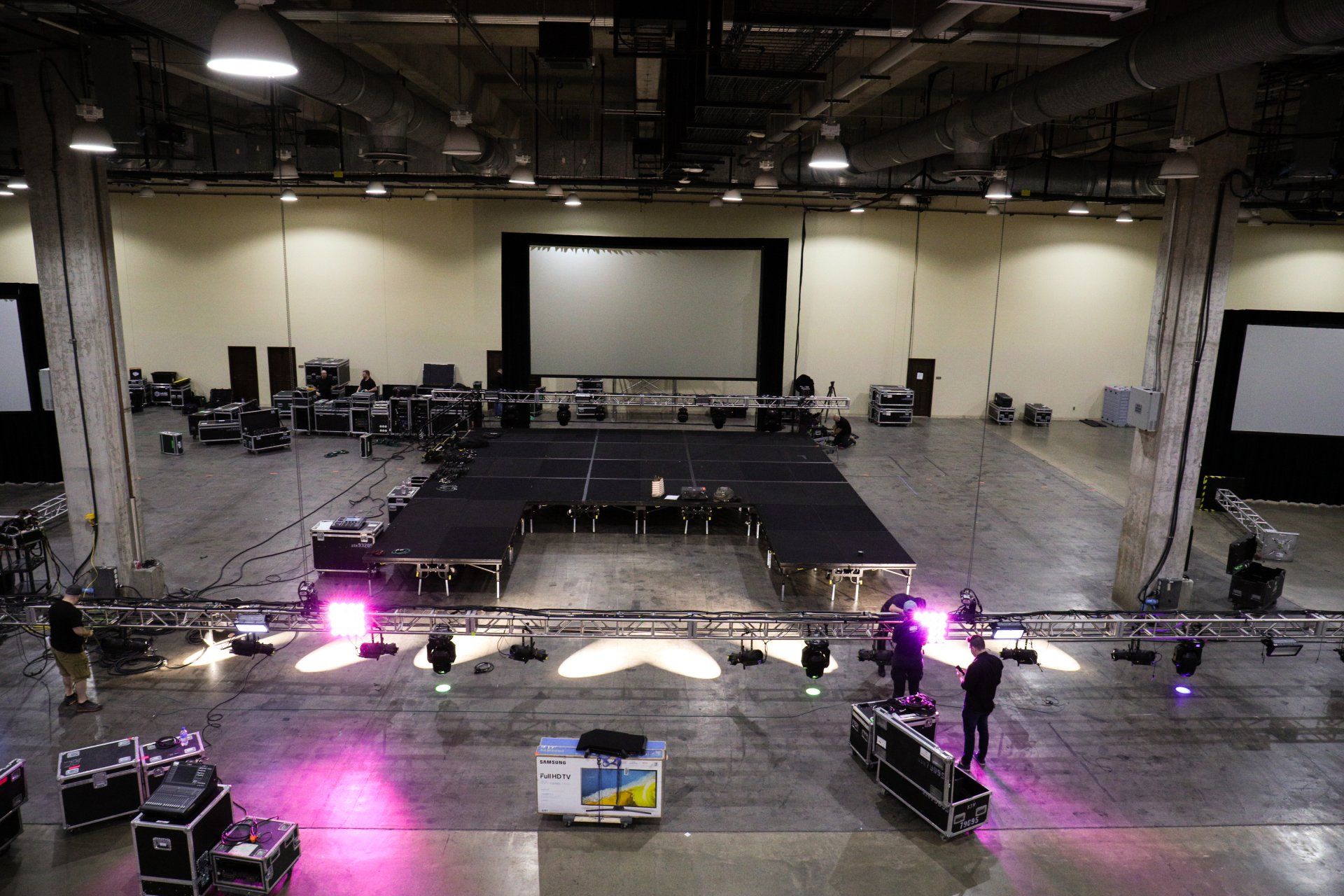 Behind-the-scenes venue setup with staging, lighting, and production equipment before a corporate event.