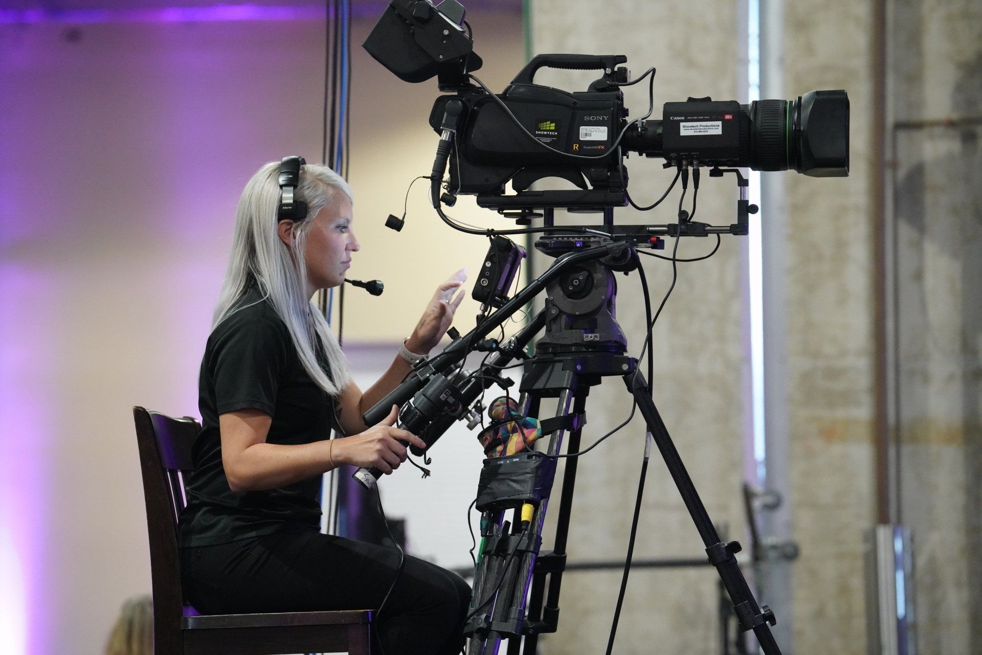 Camera operator capturing a keynote presentation for live IMAG and corporate event video production.