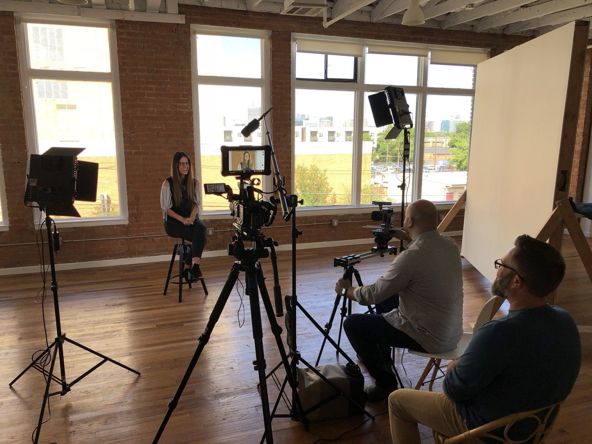Corporate interview production with a professional multi-camera setup, studio lighting, and audio recording.