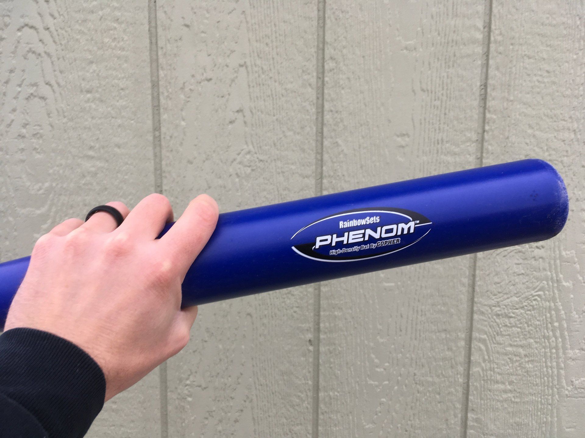 A person is holding a blue phenom baseball bat