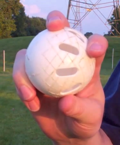 A person is holding a white ball with holes in it