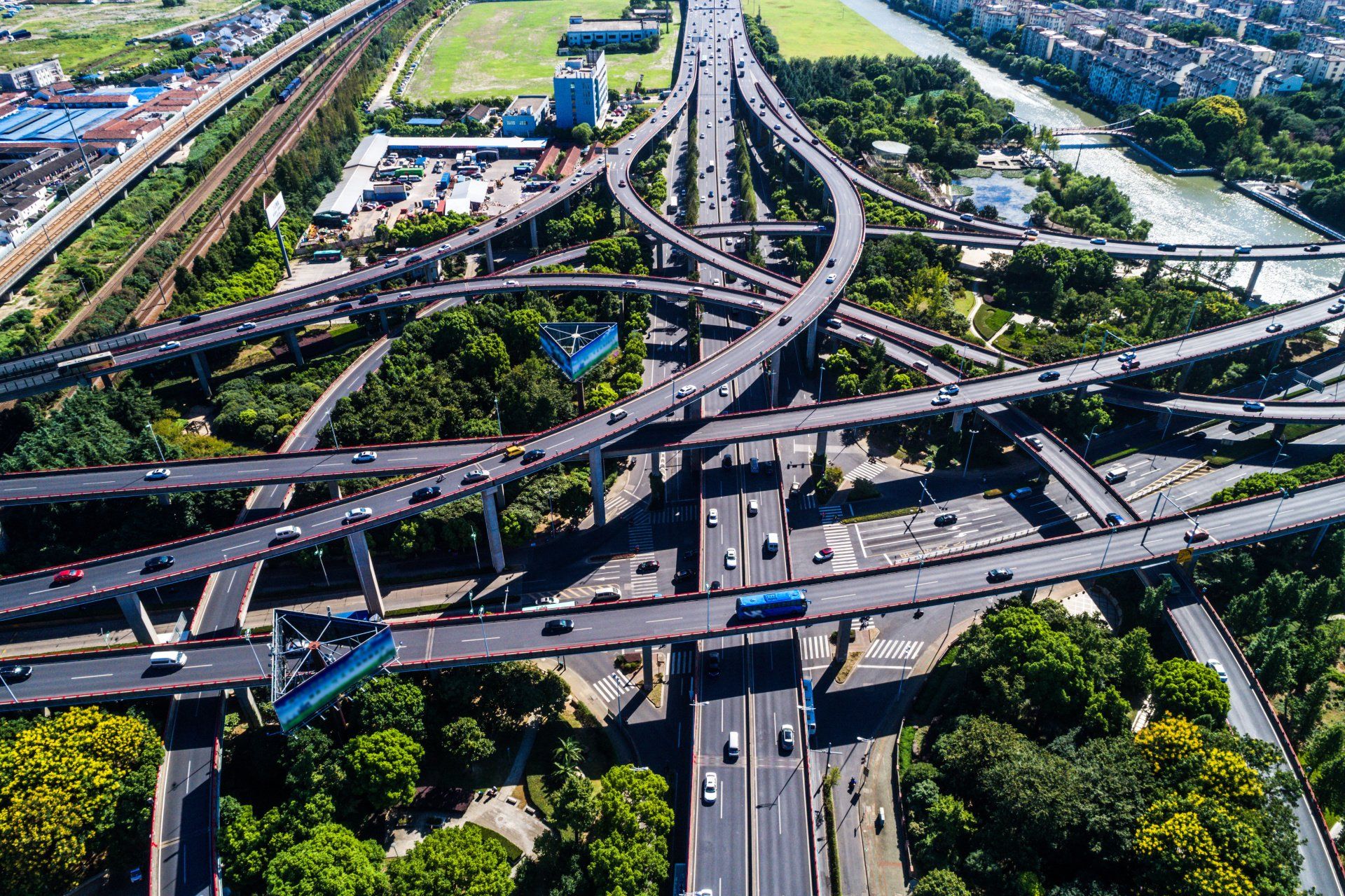 An aerial view of a busy highway intersection surrounded by trees.
