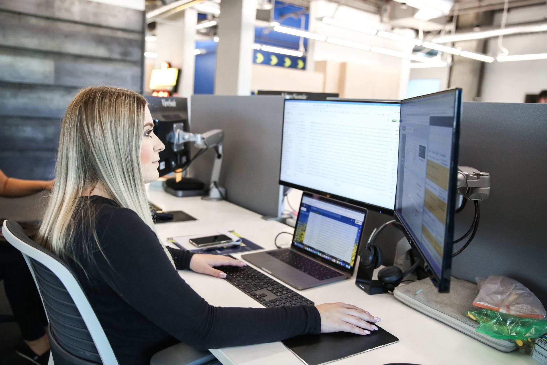 A woman is sitting at a desk in front of a computer.