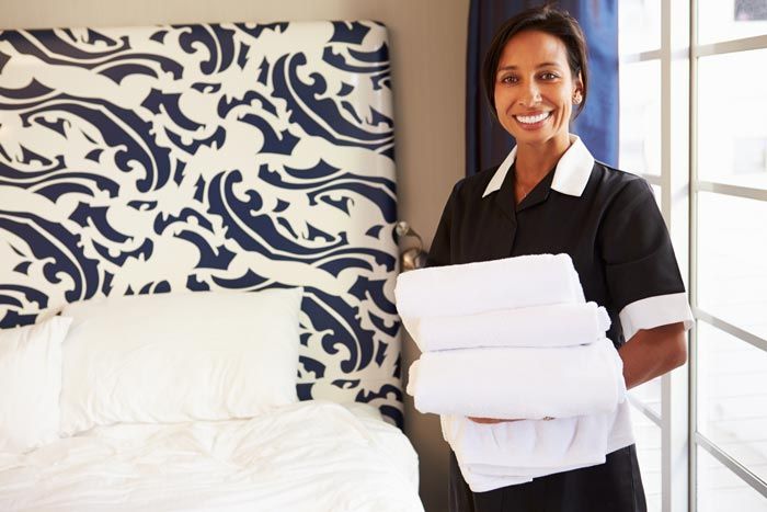 Housekeeper Holding Towels —  Peekskill, NY — Law Office of Michael J. Segreto